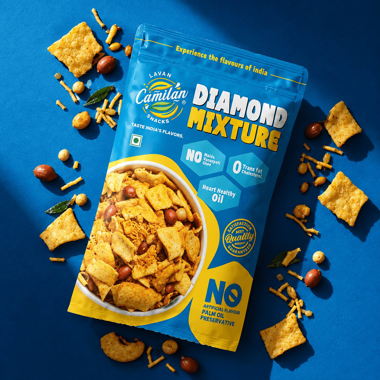 Lavan Diamond Mixture pouch flat-lay on a blue background with scattered mixture snacks